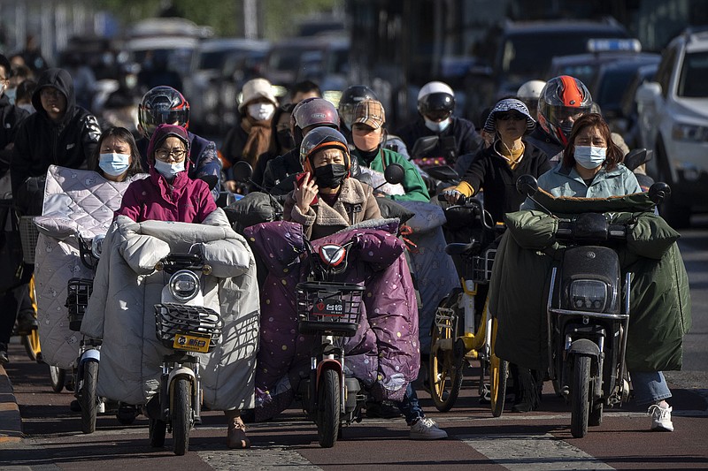 Commuters wait at an intersection Friday in Beijing, where virus cases remain lower than in some parts of China.
(AP/Mark Schiefelbein)