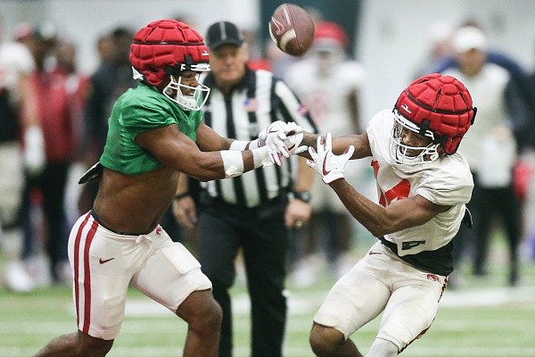 Arkansas wide receiver Bryce Stephens (14) reaches for a catch as Jalen Catalon (left) defends on Saturday, April 16, 2022 during the annual spring scrimmage at the Razorback practice field in Fayetteville. Check out nwaonline.com/220417Daily/ and nwadg.com/photos for the photo gallery.