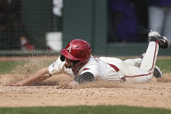 Arkansas outfielder Zack Gregory slides into home plate during a game against LSU on Saturday, April 16, 2022, in Fayetteville.