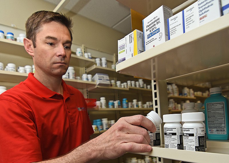 Philip Way, co-owner of Remedy Drug in Little Rock, takes a bottle of covid-19 antiviral pills from the shelf Friday. Way said his store has only filled about 30 prescriptions for the drugs. “I don’t think that there is a lot of awareness about it,” he said.
(Arkansas Democrat-Gazette/Staci Vandagriff)