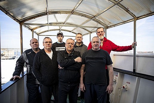 The crew of the Ocean Force (from left), Koval Vadym, 56, second engineer; Vitaliy Boyko, 53, third officer; Taupe Andrii, 19, steward; Gennadiy Shevchenko, 60, captain; Viktor Kushmila, 56, chief officer; Volodymyr Shykhov, 60, chief engineer; and Kuzhbarenko Sergiy; 56, bosun, say they’ve been following news of the war back home from their idled ship.
(TNS/The Philadelphia Inquirer/Tyger Williams)