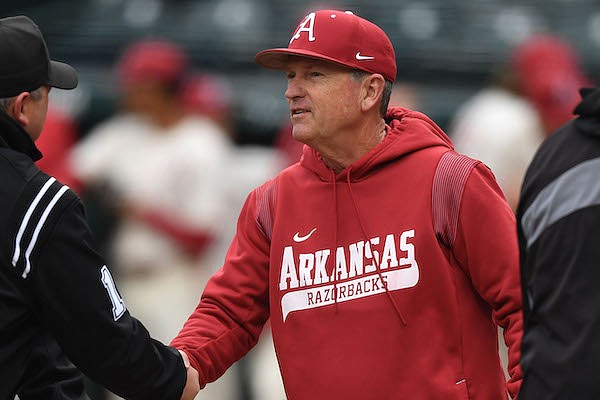 Arkansas coach Dave Van Horn shakes hands with umpires prior to a game against Arkansas State on Wednesday, April 20, 2022, in Fayetteville.