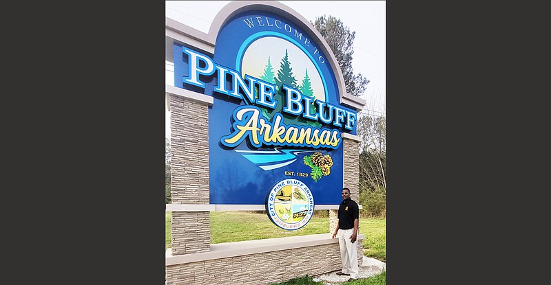 Shaun Francis, a member of the Pine Bluff Board of Tree City USA, stands near a welcome sign that prominently features trees in the design. 
(Special to The Commercial/University of Arkansas at Pine Bluff)