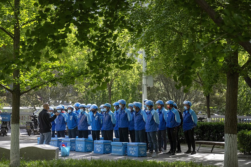 Delivery drivers gather before the start of their work day in Beijing on Tuesday. Companies that benefited from supply chains that run through China are now dealing the country’s covid-19 lockdowns that have confined millions to their homes.
(AP/Mark Schiefelbein)