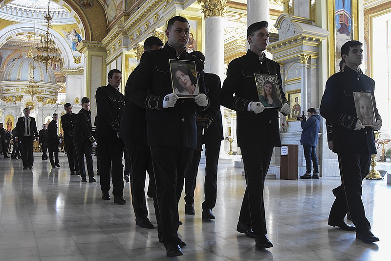 Men carry portraits of (from left) Valerya Glodan, 28; her mother Lyudmila Yavkina, 54; and Glodan’s 3-month-old daughter Kira during a funeral ceremony Wednesday at the Transfiguration Cathedral Wednesday in Odessa, Ukraine. According to Ukrainian officials, those three and two other people were killed and 18 injured in a missile attack Saturday in the Black Sea port city.
(AP/Max Pshybyshevsky)