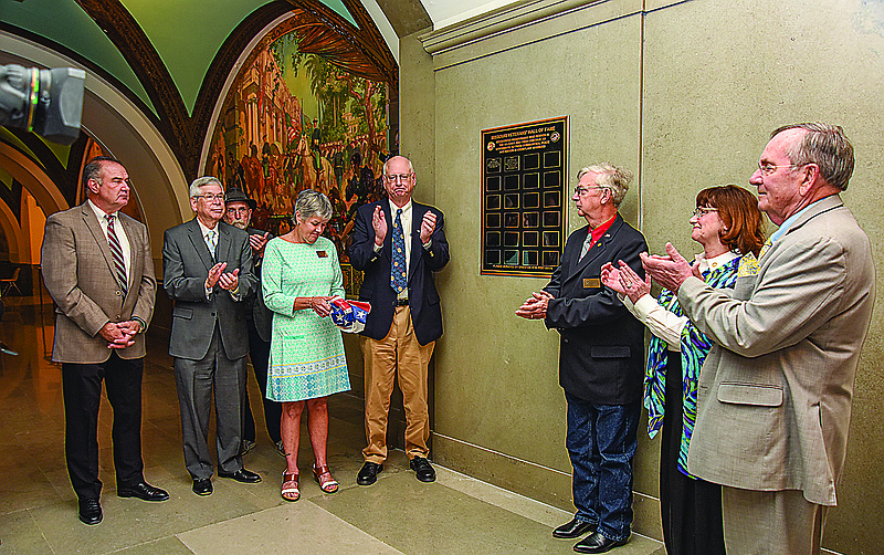Just outside of the Missouri lieutenant governor's office on the state Capitol's second floor is the stretch of paintings known since 1919 as the Hall of Sailors and Soldiers. At the beginning of the hallway now is a plaque indicative indicating members of the the Missouri Veterans Hall of Fame. The plaque was unveiled Wednesday, April 27, 2022, during a brief ceremony hosted by Lt. Gov. Mike Kehoe, at left. He was joined by MVHOF board members and other interested parties. (Julie Smith/News Tribune photo)