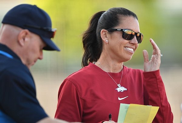 Arkansas coach Courtney Deifel laughs Tuesday, April 26, 2022, with umpires before the start of the Razorbacks' 3-2 win over Central Arkansas at Bogle Park in Fayetteville.