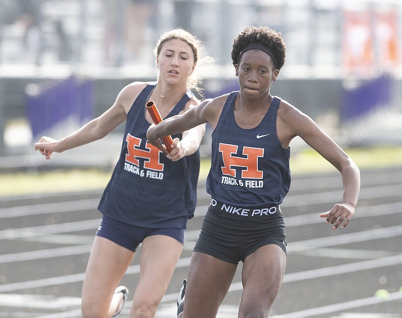 Rogers Heritage High School’s Ella Fosse hands off the baton to Katherine Toney during the 4x200-meter relay at the 6A-West Conference track and field meet Wednesday in Fayetteville.
(NWA Democrat-Gazette/J.T. Wampler)