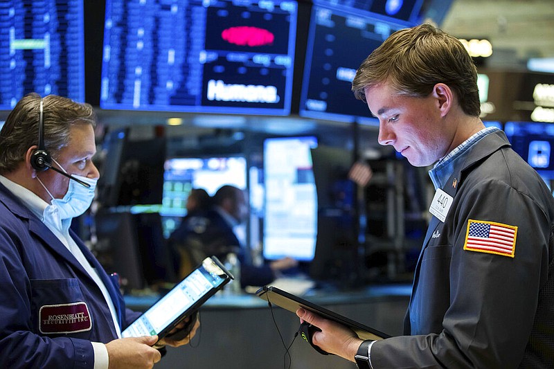 In this undated photo provided by the New York Stock Exchange, Wall Street traders John Santiago (left) and Colin Gaven work on the floor in New York. (Courtney Crow/New York Stock Exchange via AP)