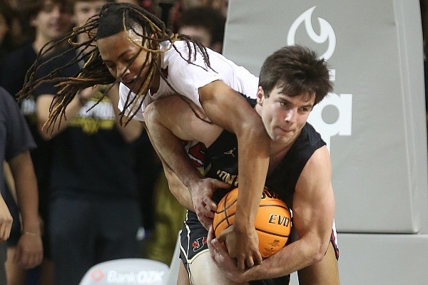 Marion's Terrion Burgess (left) fights for a rebound with Jonesboro's John Paul Pickens (right) during the second quarter of Jonesboro's 55-28 win in the Class 5A boys basketball state championship game on Thursday, March 10, 2022, at Bank OZK Arena in Hot Springs.