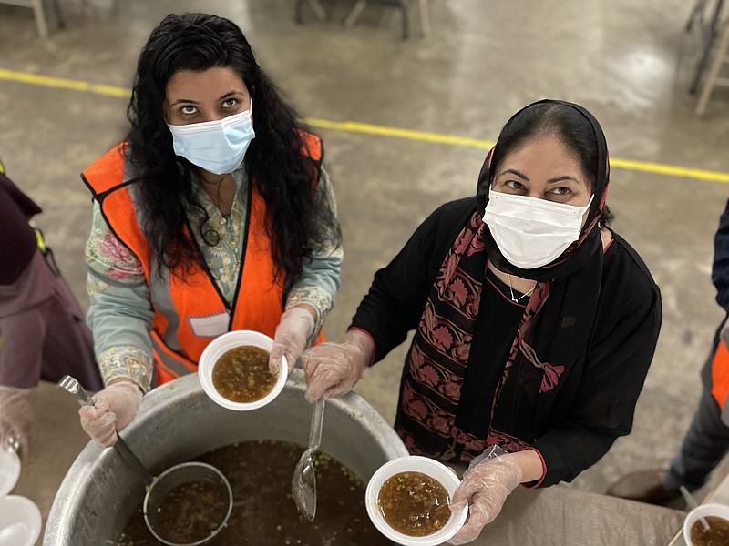 Shashataw Hoque Logno (left) and Summaiya Kamran dish up hot-and-sour soup Monday evening to serve to guests at Madina Institute and Mosque in Little Rock. During Ramadan, many Muslims have been gathering there in the evenings to break the fast. More photos at arkansasonline.com/430mosque.
(Arkansas Democrat-Gazette/Frank E. Lockwood)