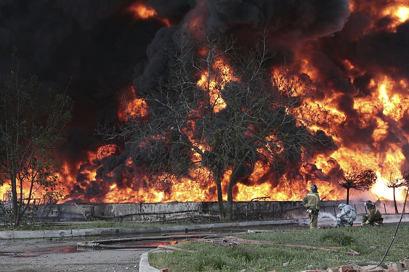 Donetsk People Republic Emergency Situations Ministry firefighters work to control a fire at an oil depot after missiles struck the facility in an area controlled by Russian-backed separatist forces in Makiivka, 94 miles east of Donetsk, eastern Ukraine, on Wednesday. Europe’s plan to refuse Russian oil threatens to take millions of barrels off a global market.
(AP Photo)