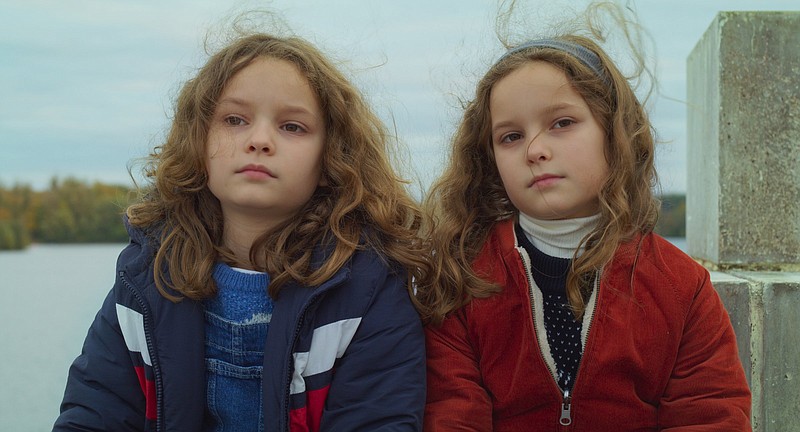 Nelly and Marion (twin sisters Josephine and Gabrielle Sanz) bound over forts built of branches and incomprehensible loss in Celine Sciamma’s sweet and poignant fable “Petite Maman.”