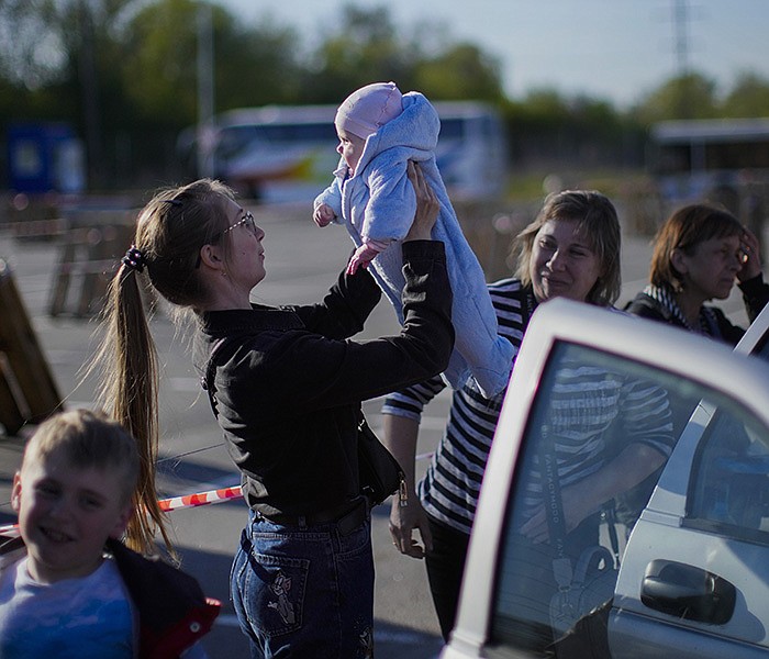 A woman holds up a baby Friday as a family that fled from Enerhodar, Ukraine, is reunited upon arriving at a reception center for displaced people in Zaporizhzhia. Thousands of Ukrainians continue to flee Russian-occupied areas. More photos at arkansasonline.com/ukrainemonth3/.
(AP/Francisco Seco)
