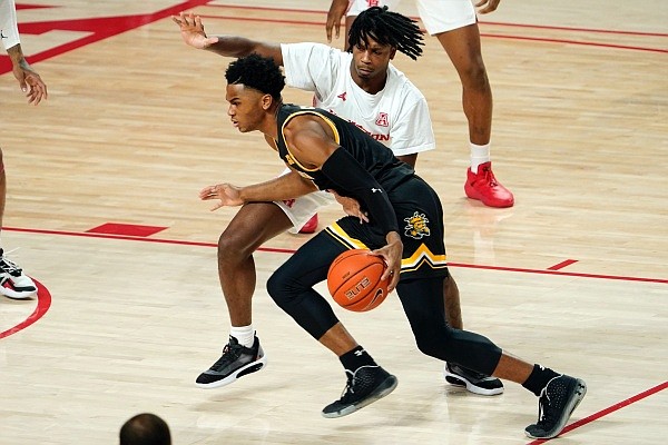 Wichita State's Ricky Council IV, front, is fouled by Houston's Tramon Mark during the first half of an NCAA college basketball game Wednesday, Jan. 6, 2021, in Houston. (AP Photo/David J. Phillip)