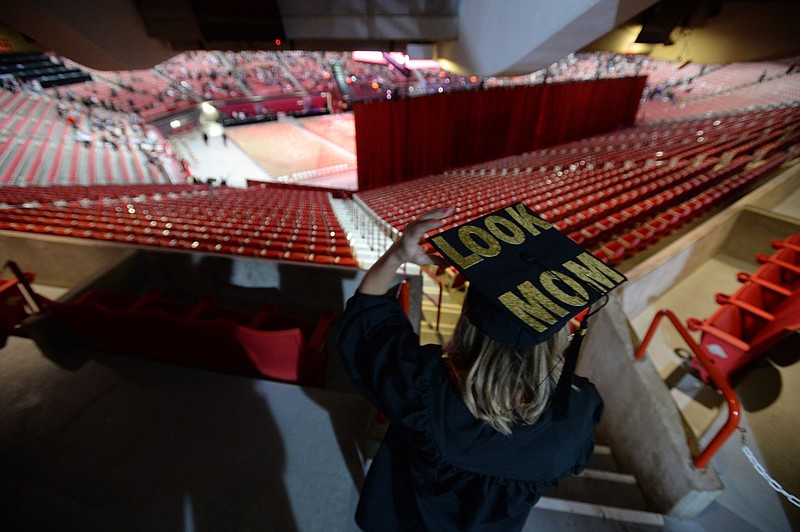 Amanda Mowrey of Tulsa fixes her mortarboard as she looks for family during the University of Arkansas, Fayetteville fall commencement in Bud Walton Arena on the university campus in this Dec. 21, 2019 file photo. (NWA Democrat-Gazette/Andy Shupe)