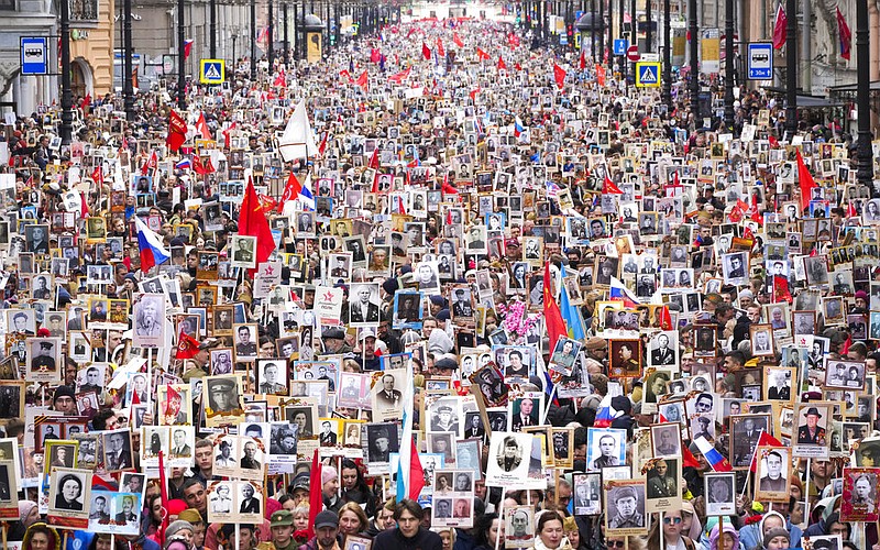 People carry portraits of relatives who fought in World War II, during the Immortal Regiment march in St. Petersburg, Russia, Monday, May 9, 2022, marking the 77th anniversary of the end of World War II. (AP Photo/Dmitri Lovetsky)