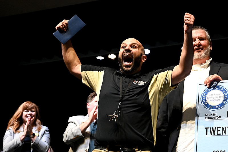 Grant Harbison, the Jonesboro High School band director, celebrates as he walks onto the stage Wednesday to receive the Milken Educator Award of $25,000 during a school assembly at the Academies at Jonesboro High School. More photos at arkansasonline.com/512milken/.
(Arkansas Democrat-Gazette/Stephen Swofford)