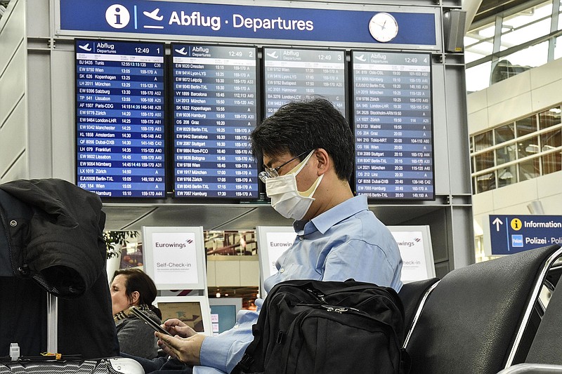 A passenger with a mask waits for his flight at the airport in Dusseldorf, Germany, in March 2020. The European Union Aviation Safety Agency said Wednesday that from next week onward it is no longer recommending the use of medical masks at airports and on planes due to the coronavirus.
(AP/Martin Meissner)