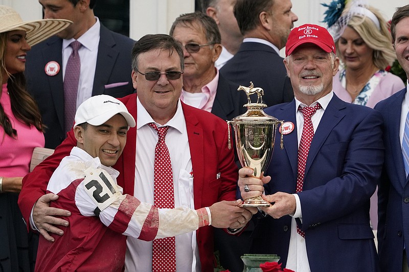Jockey Sonny Leon (21) celebrates after winning the 148th running of the Kentucky Derby horse race at Churchill Downs Saturday, May 7, 2022, in Louisville, Ky. On the right is owner of Kentucky Derby winning horse Rich Strike, Richard Dawson. (AP Photo/Jeff Roberson)