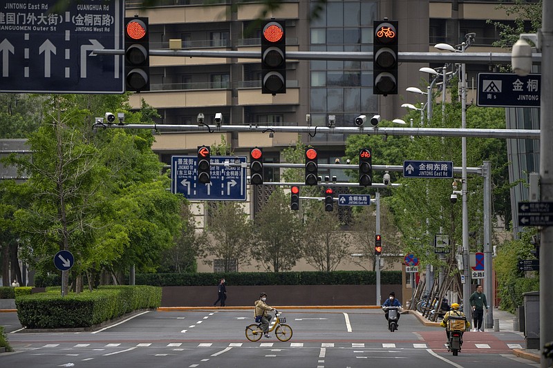 A man rides a bicycle Thursday across a quiet intersection in the central business district of Bejiing. Most people in the area were ordered to work from home.
(AP/Mark Schiefelbein)