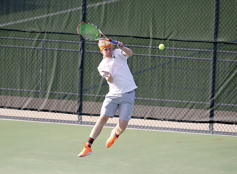 Jacob Zerr of Helias jumps as he hits a forehand during his doubles match against Capital City in the Class 2 District 5 Tournament championship dual Wednesday at the Crusader Athletic Complex. (Greg Jackson/News Tribune)