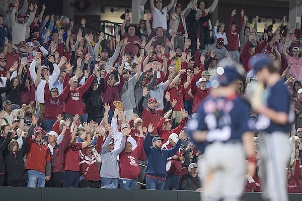 Arkansas fans cheer while Ole Miss players conference during a game Saturday, April 30, 2022, in Fayetteville.