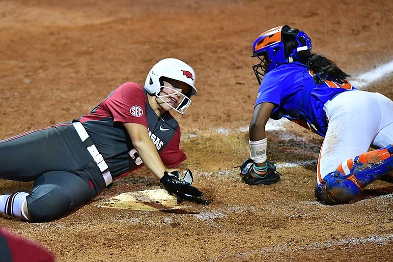 Arkansas third baseman Hannah Gammill (left) scores on a throwing error by Florida’s Rylee Trlicek to make it 1-1 in the fourth inning Friday in a 4-1 victory over Florida in the semifinals of the SEC Softball Tournament in Gainesville, Fla. Arkansas will face Missouri at 4 p.m. today for the championship.
(Photo courtesy University of Arkansas Athletics)