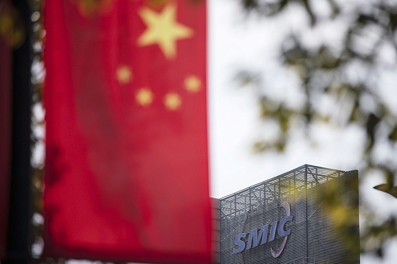 A Chinese flag is seen near a logo atop the Semiconductor Manufacturing International Corp. headquarters in Shanghai in March 2021.
(Bloomberg/Qilai Shen)