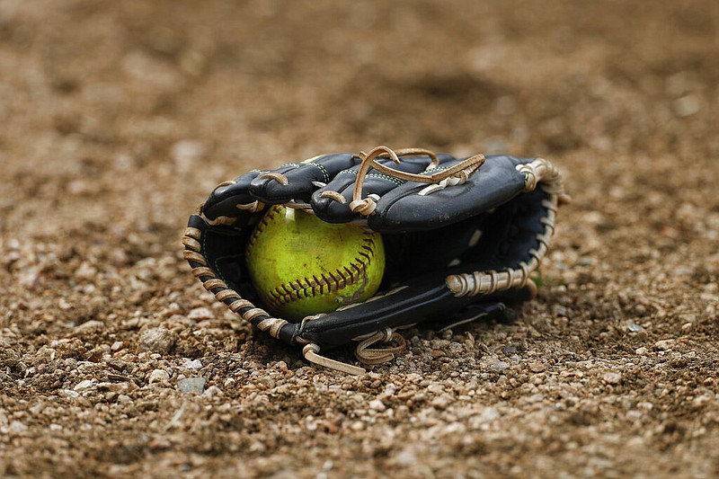 A yellow softball is shown in a glove on a field in this April 5, 2019 file photo. (AP/Aaron M. Sprecher)