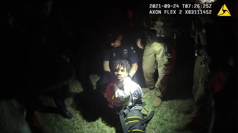 In this image from body camera video provided by Sedgwick County, police put Cedric â€œC.J.â€ Lofton, 17, into a body-length restraining device called a WRAP outside his home in Wichita, Kan., on Sept. 24, 2021. His foster father, unable to deal with a teen who seemed to be in the throes of schizophrenia, had called Wichita police. When they arrived, Cedric refused to leave the porch and go with them; he was obstinate but afraid, meek but frantic. (Sedgwick County via AP)