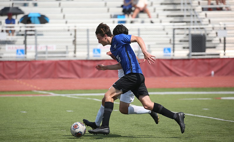 Jonathan Caldwell, center, moves the ball down the field for Conway during a playoff game against Little Rock Catholic in Conway on Friday, May 13, 2022. See more photos at arkansasonline.com/514soccer/ (Arkansas Democrat-Gazette/Colin Murphey)