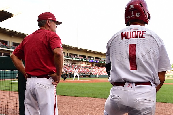 Arkansas coach Dave Van Horn (left) and second baseman Robert Moore watch from the dugout during a game against Vanderbilt on Friday, May 13, 2022, in Fayetteville.