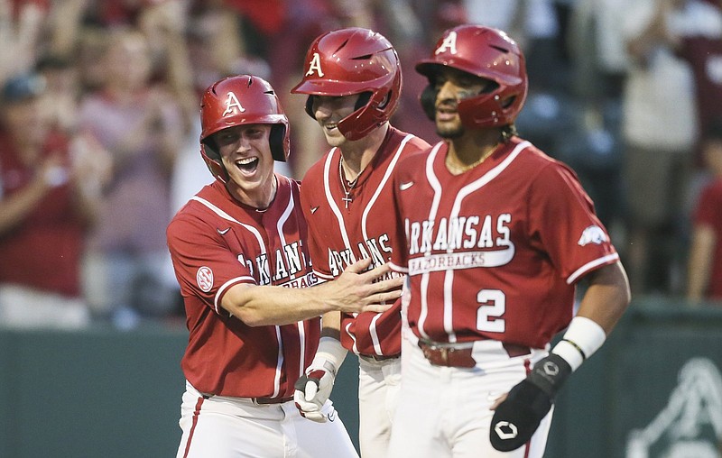 Cayden Wallace (from left), Jace Bohrofen and Jalen Battles celebrate a run during the fourth inning of Saturday’s game against Vanderbilt at Baum-Walker Stadium in Fayetteville. The game was suspended because of weather in the sixth inning with Arkansas ahead 8-6 and is set to resume at 11 a.m. today. More photos at arkansasonline.com/515vandyua/
(NWA Democrat-Gazette/Charlie Kaijo)
