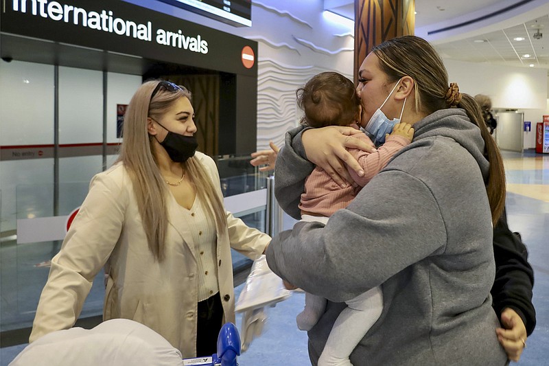 Families embrace after a flight from Los Angeles arrived at Auckland International Airport as New Zealand’s border opened for visa-waiver countries May 2. New Zealand will reopen its borders to tourists from all countries by July
(New Zealand Herald via AP/Jed Bradley)