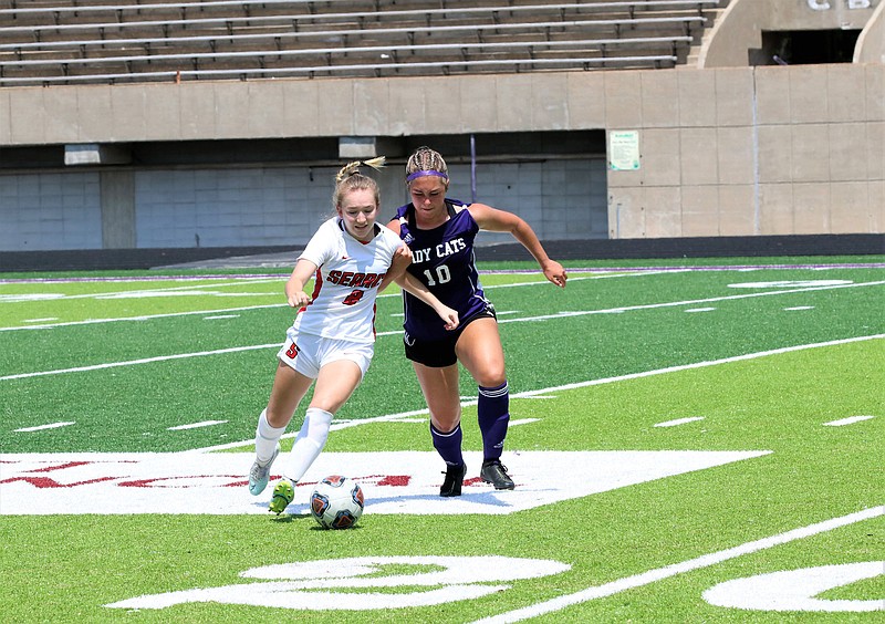 Searcy’s Avery Meadows (left) tries to keep control of the ball Saturday as El Dorado’s Millee Mobley runs alongside during the Lady Lions’ 6-0 victory over the Lady Wildcats in the semifinals of the Class 5A girls soccer state tournament at Memorial Stadium in El Dorado.
(El Dorado News-Times/Penny Chanler)