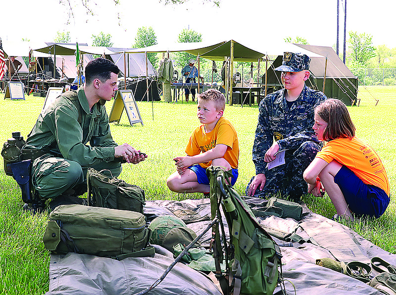 Re-enactors show the public what life was like in the Vietnam Era on May 14, 2022, at the Museum of Missouri Military History, in Jefferson City. Left to right, Austin Grant, Kenny Schulte (7), Mason Carel and Jazmyne Schulte (9) look at military equipment. (Kate Cassady/News Tribune photo)