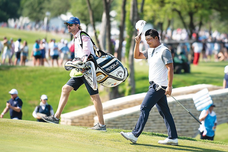 K.H. Lee takes off his cap as he is introduced while walking onto the green at the 18th hole during Sunday’s final round of the AT&T Byron Nelson in McKinney, Texas. (Emil Lippe/Associated Press)