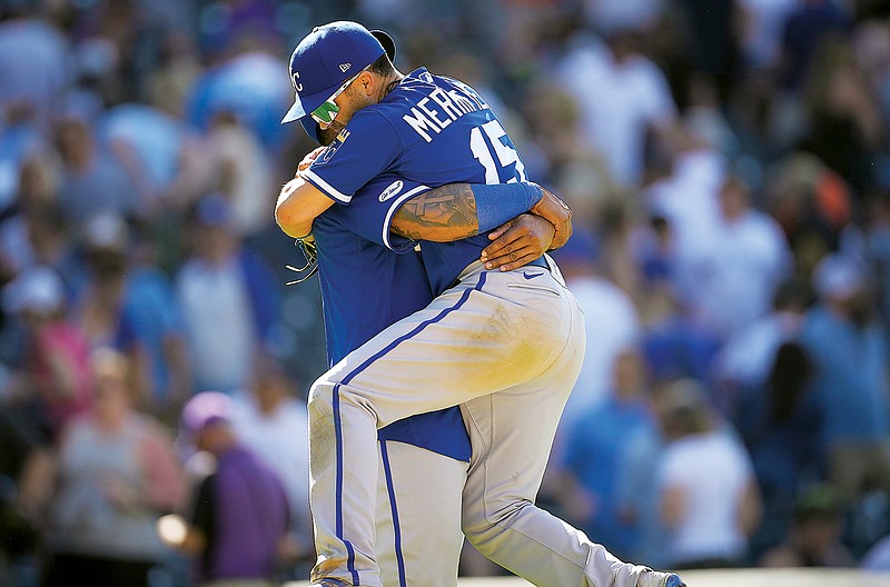 Royals second baseman Whit Merrifield jumps into the arms of Salvador Perez to celebrate after Sunday’s win against the Rockies in Denver. (Associated Press)