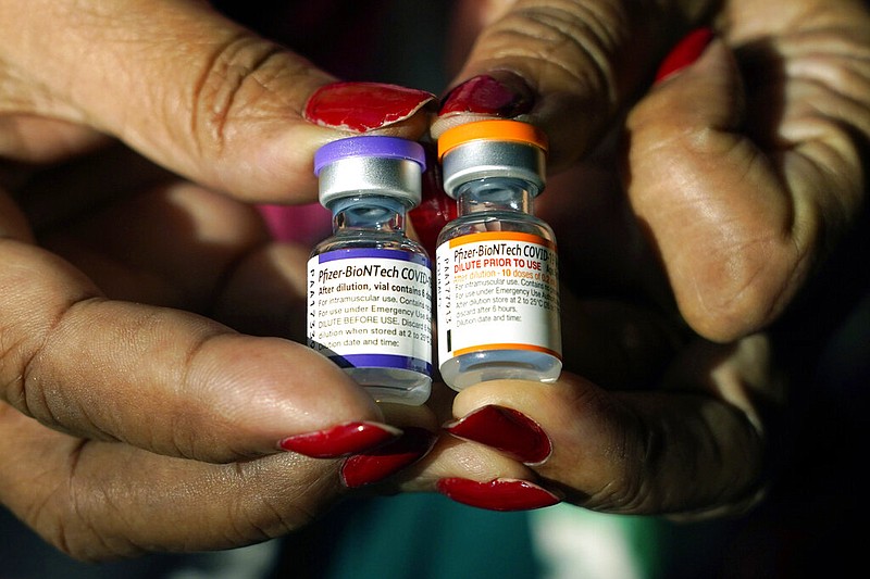 FILE - A nurse holds a vial of the Pfizer covid-19 vaccine for children ages 5 to 11, right, and a vial of the vaccine for adults, which has a different colored label, at a vaccination station in Jackson, Miss., Tuesday, Feb. 8, 2022. (AP/Rogelio V. Solis, File)