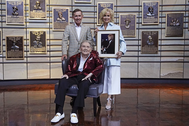 Music executive Joe Galante (standing) rocker Jerry Lee Lewis, and singer Lorrie Morgan, widow of country singer Keith Whitley, gather Tuesday at the Country Music Hall of Fame in Nashville, Tenn. Morgan is holding a portrait of her late husband.
(AP/Mark Humphrey)