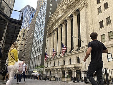People pass the New York Stock Exchange on Wednesday in New York. Stocks tumbled on Wall Street after a solid rally Tuesday as markets remain volatile.
(AP/Peter Morgan)
