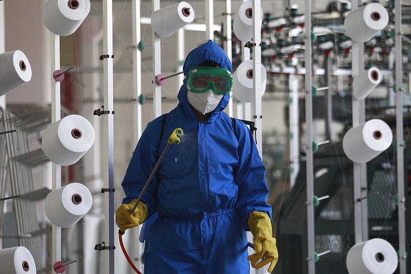 An employee of Songyo Knitwear Factory in Songyo district disinfects the work floor in Pyongyang, North Korea, Wednesday, after Kim Jong Un said Tuesday his party would treat the country’s outbreak under the state emergency. Video at arkansasonline.com/519kimcovid/.
(AP/Jon Chol Jin)