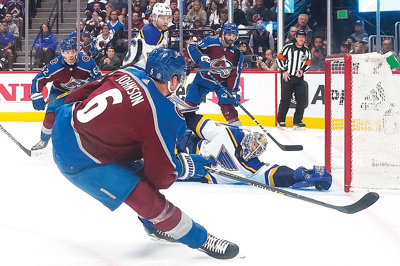 Blues goaltender Jordan Binnington makes a save against Avalanche defenseman Erik Johnson during the second period in Tuesday night's Game 1 of a second-round playoff series in Denver. (Associated Press)