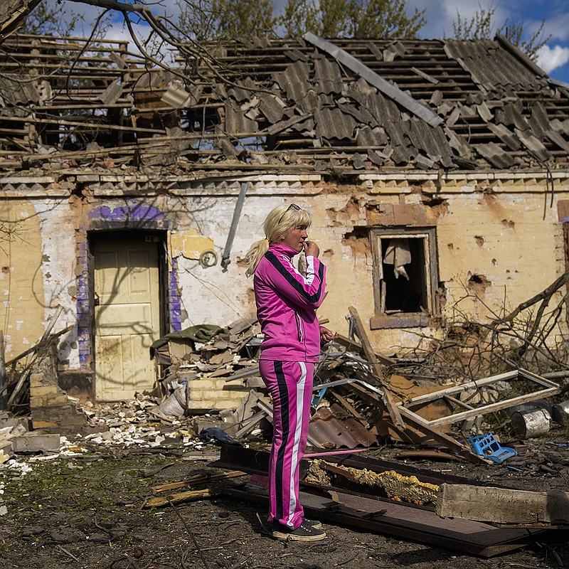 Iryna Martsyniuk, 50, stands next to her house in Velyka Kostromka village, Ukraine, after it was heavily damaged Thursday in a Russian attack. Martsyniuk and her three young children were at home in the village a few miles from the front lines but were unharmed. More photos at arkansasonline.com/520ukrainemonth3/.
(AP/Francisco Seco)
