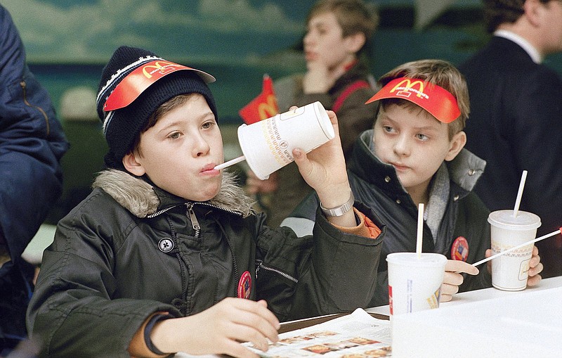 Young Muscovites checks out a new taste sensation for the Soviet Union, hamburgers and soft drinks in Moscow on Jan. 31, 1990.
(AP/Rudi Blaha)