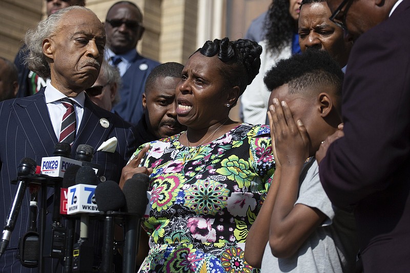 Tirzah Patterson, former wife of Buffalo shooting victim Heyward Patterson, speaks as her son, Jacob Patterson, 12, covers his face during a press conference outside the Antioch Baptist Church on Thursday, in Buffalo, N.Y.
(AP/Joshua Bessex)
