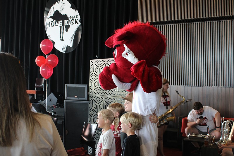 Big Red poses for a photo with fans during the ONE Razorback Roadshow at Mulekick at MAD on Wednesday, May 18. (Caitlan Butler/News-Times)