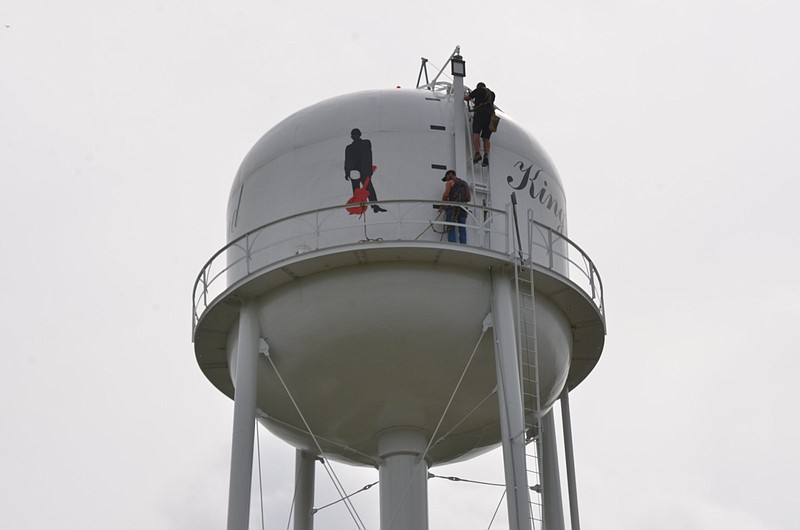 Workers repair a bullet hole in the Kingsland water tower on Thursday. 
(Special to The Commercial/Richard Ledbetter)