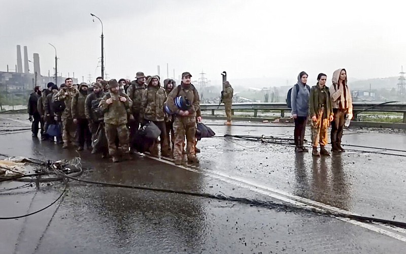 In this photo taken from video released by the Russian Defense Ministry on Thursday, May 19, 2022, shows Ukrainian servicemen as they leave the besieged Azovstal steel plant in Mariupol, in territory under the government of the Donetsk People's Republic, eastern Ukraine. (Russian Defense Ministry Press Service via AP)